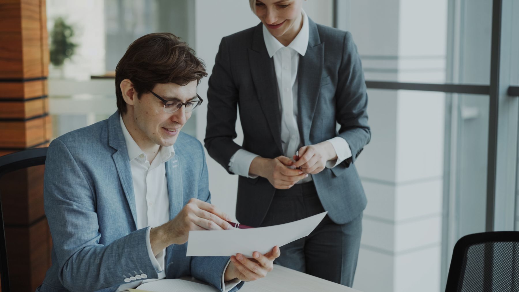 Zakelijke professionals bespreken en beoordelen documenten in een moderne kantooromgeving.